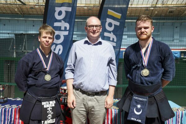 Pictured: AB Jones and AB Nolan from the Royal Navy win gold for the team kendo kata during the  Martial Arts Inter Services Championship 2022 held at HMS Nelson, Portsmouth. 

MARTIAL ARTS INTER SERVICES CHAMPIONSHIP 2022

On 16th-17th July 2022, the Royal Navy Royal Marines Mixed Martial Arts Association hosted the Martial Arts Inter Services Championship 2022 at HMS Nelson, Portsmouth. It is the first Martial Arts Inter Services Championship since 2019, as COVID-19 discontinued 2020 and 2021 championships. 

Service members from a variety of martial arts disciplines, including Brazilian Jiu-Jitsu (BJJ), World Taekwondo Federation (WT), International Taekwondo Federation (ITF), and Kendo, competed in the Martial Arts Inter Services Championship 2022. The Army Karate team was unable to compete, so a different championship will be held for the Karate team later this year.

International Taekwondo Federation and Kendo competition was held on Saturday, 16th July 2022; World Taekwondo Federation and Brazilian Jiu-Jitsu competition was held on 17th July 2022.  

Kendo is a modern Japanese martial art, descended from kenjutsu, one of traditional Japanese martial arts, swordsmanship, that is bamboo swords as well as protective armour. Kendo competition consist of 3 Royal Navy and 3 Army competitors. AB Nolan, AB Howell and Major Bowlem won gold for team sparring and AB Nolan won gold for kata.